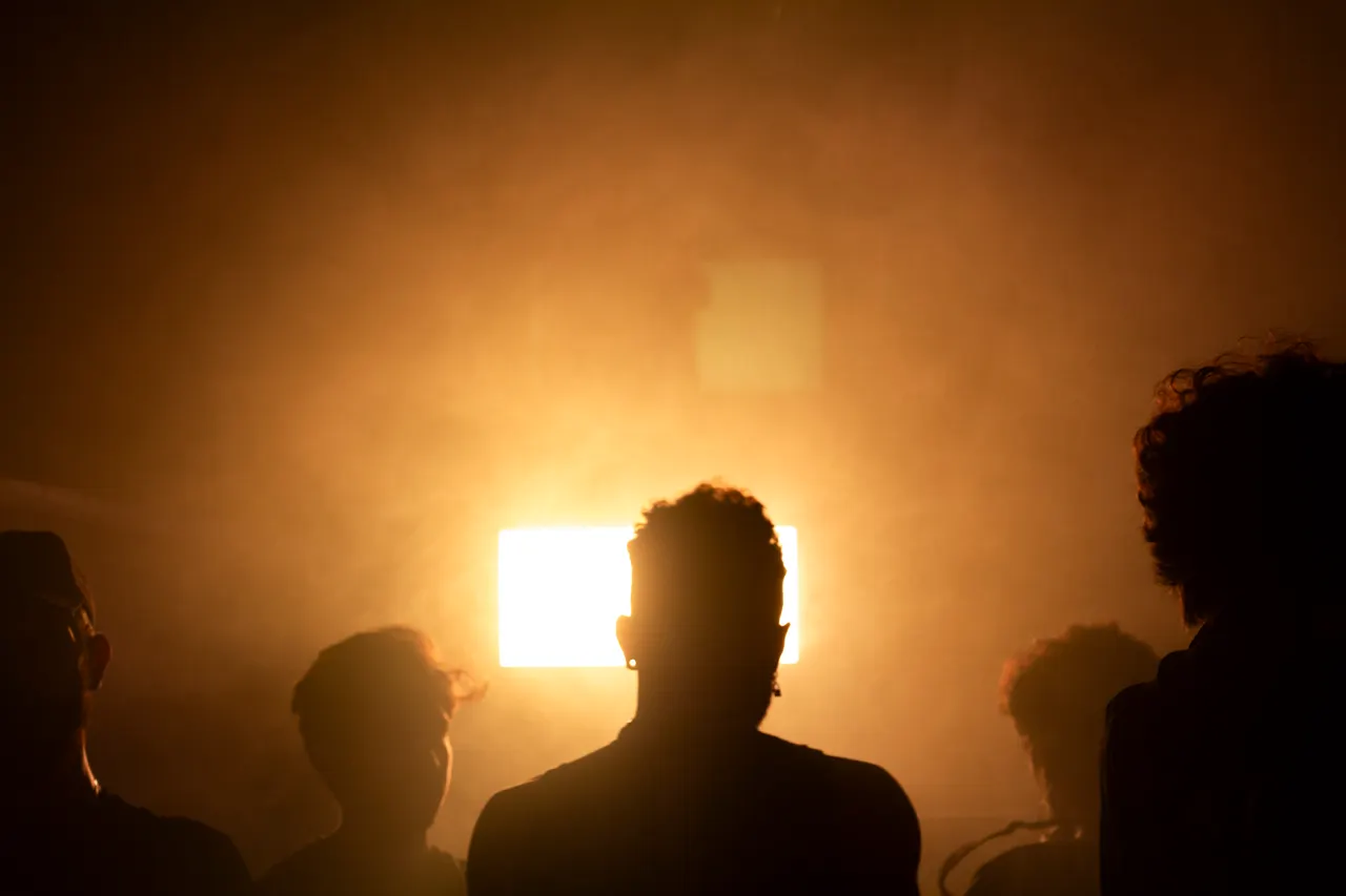 A equipe em silhueta contra uma luz laranja.